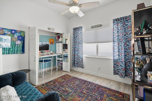 interior space featuring ceiling fan, baseboards, and wood finished floors