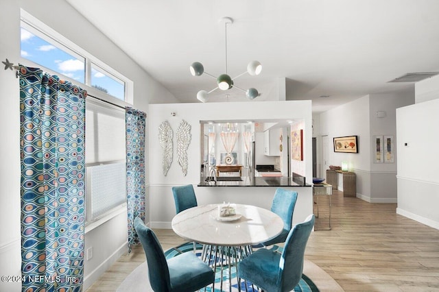 dining area featuring baseboards, vaulted ceiling, and light wood-style floors