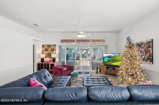 living room featuring a ceiling fan, visible vents, and wood finished floors