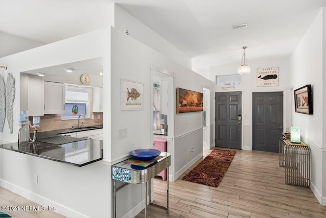 entrance foyer featuring light wood-type flooring, visible vents, and baseboards