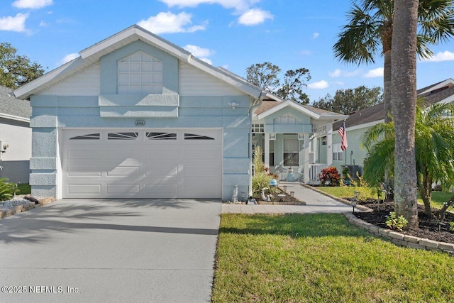 view of front of house with an attached garage, a front lawn, and concrete driveway