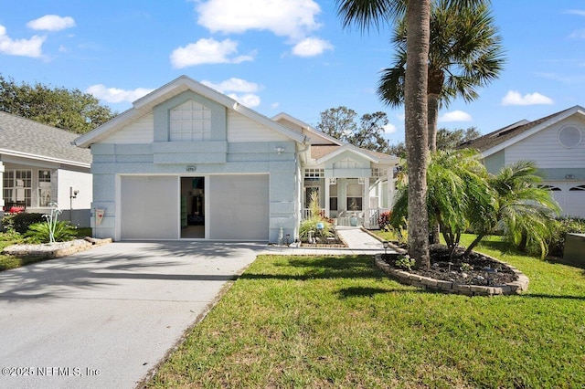 view of front of home with an attached garage, driveway, and a front lawn