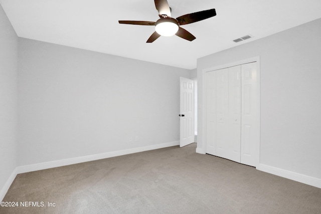 unfurnished bedroom featuring ceiling fan, carpet floors, and a closet