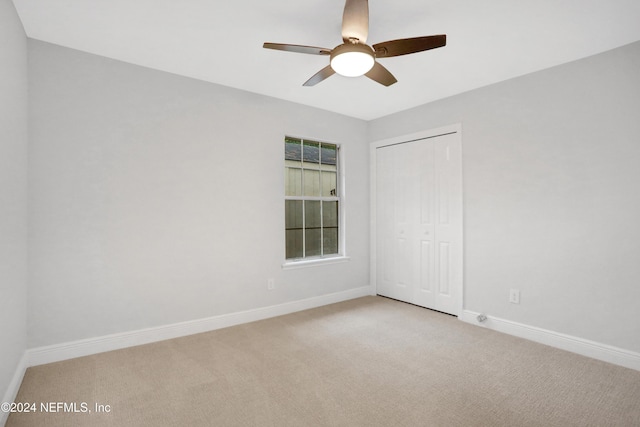 carpeted empty room featuring ceiling fan