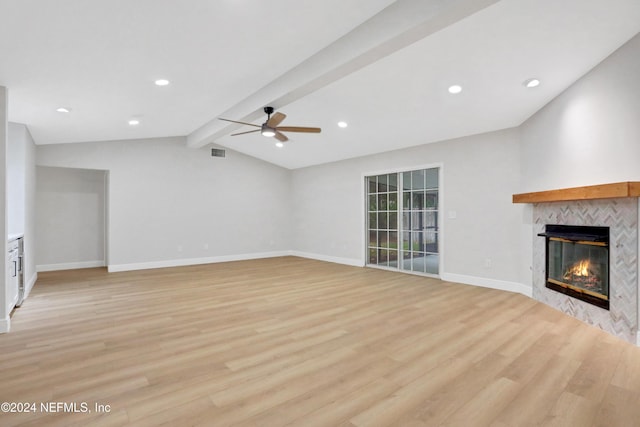 unfurnished living room with vaulted ceiling with beams, light hardwood / wood-style floors, a fireplace, and ceiling fan