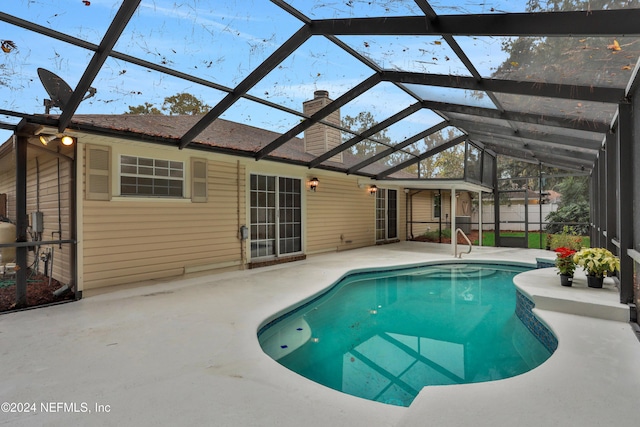 view of swimming pool with a patio and glass enclosure