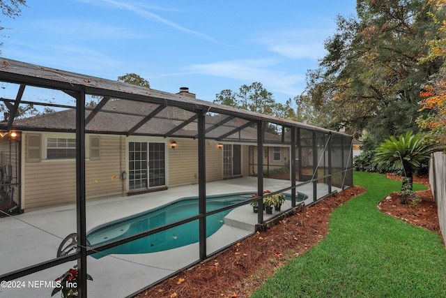 view of swimming pool with a yard, a patio, and a lanai