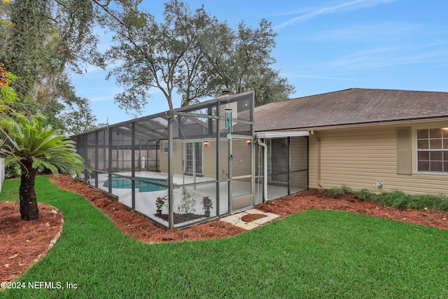 rear view of house with a patio area, a lanai, and a yard