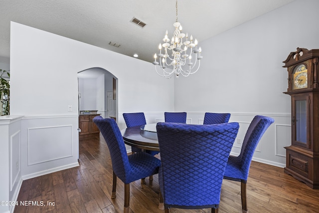 dining room featuring a textured ceiling, a chandelier, and dark hardwood / wood-style floors