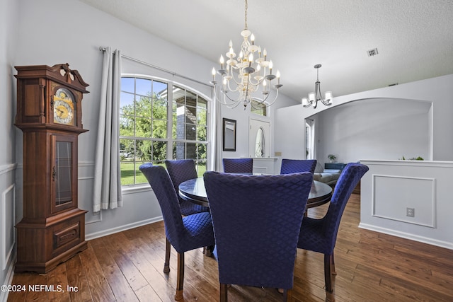 dining space featuring dark hardwood / wood-style flooring, a textured ceiling, and a chandelier