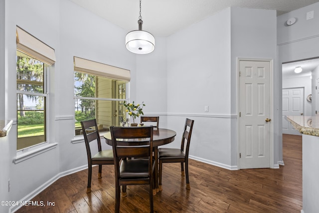 dining space with dark hardwood / wood-style flooring and a textured ceiling