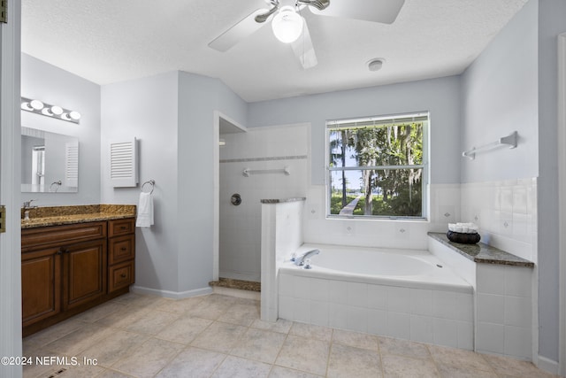 bathroom with tile patterned floors, vanity, shower with separate bathtub, and a textured ceiling