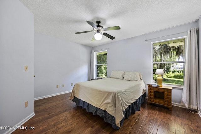 bedroom featuring a textured ceiling, ceiling fan, and dark wood-type flooring