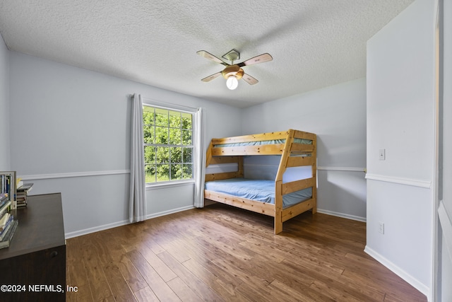 unfurnished bedroom with ceiling fan, dark hardwood / wood-style flooring, and a textured ceiling