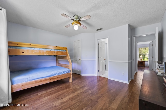 bedroom with a textured ceiling, dark hardwood / wood-style floors, and ceiling fan