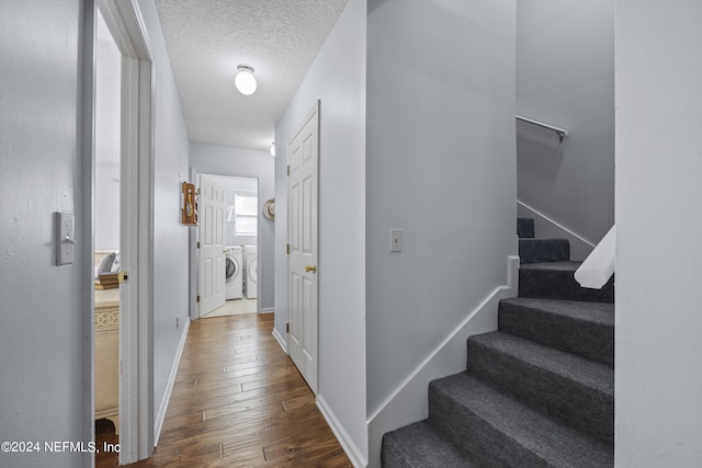 interior space featuring hardwood / wood-style flooring, a textured ceiling, and washing machine and clothes dryer