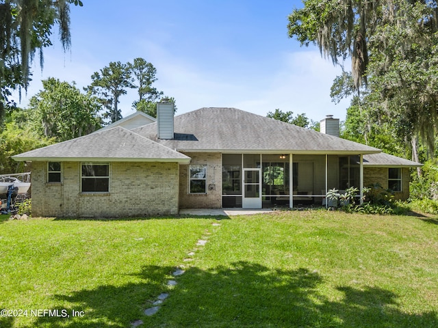 rear view of property with a sunroom and a yard