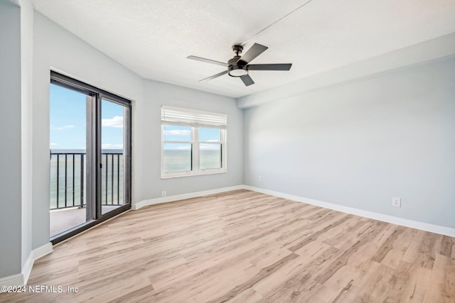 unfurnished room with ceiling fan, light hardwood / wood-style floors, and a textured ceiling