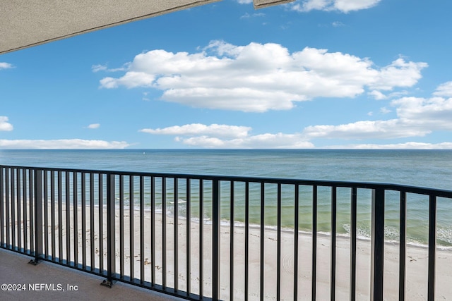 balcony with a water view and a beach view