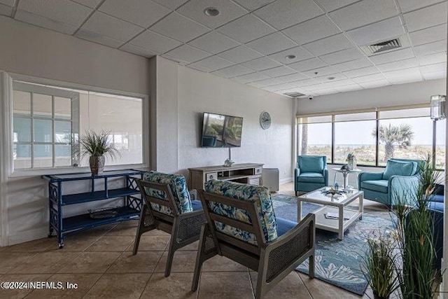 tiled living room with a paneled ceiling