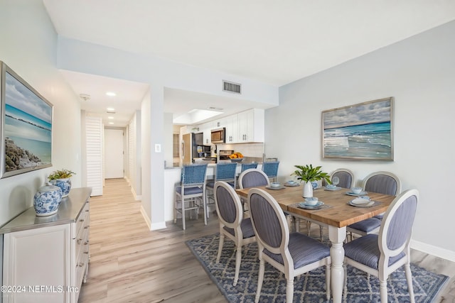 dining space with light wood-type flooring