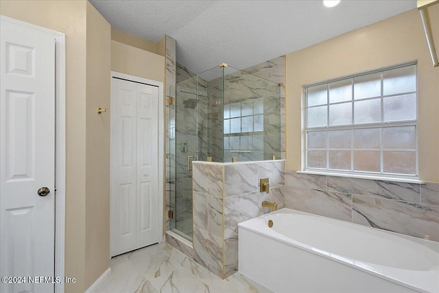 bathroom featuring a textured ceiling and independent shower and bath