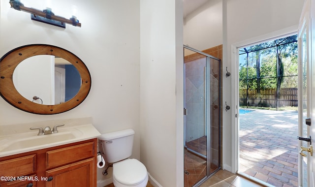 bathroom with vanity, toilet, and a shower with door