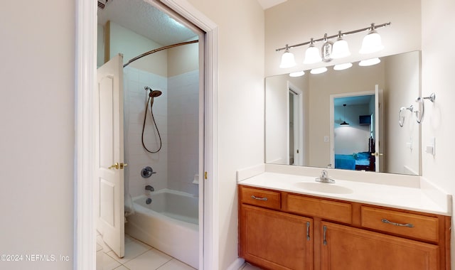 bathroom featuring tile patterned flooring, vanity, and tiled shower / bath