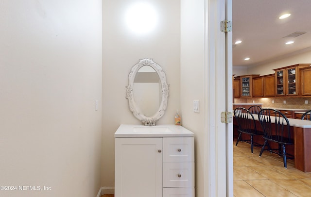 bathroom with backsplash, tile patterned flooring, and vanity