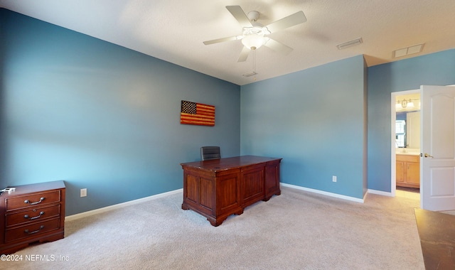 carpeted office space featuring ceiling fan