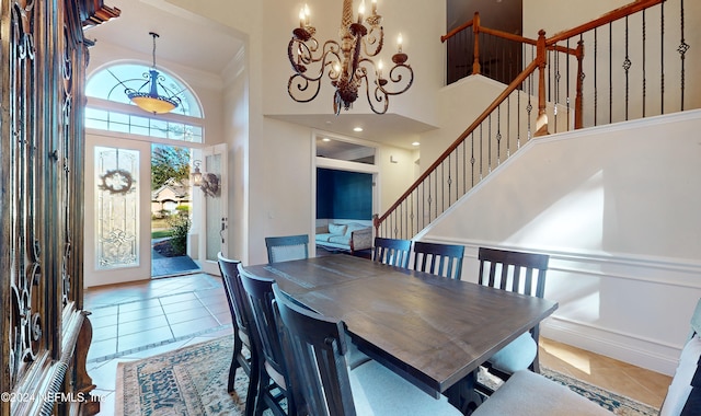 dining area with tile patterned flooring, a towering ceiling, and ornamental molding