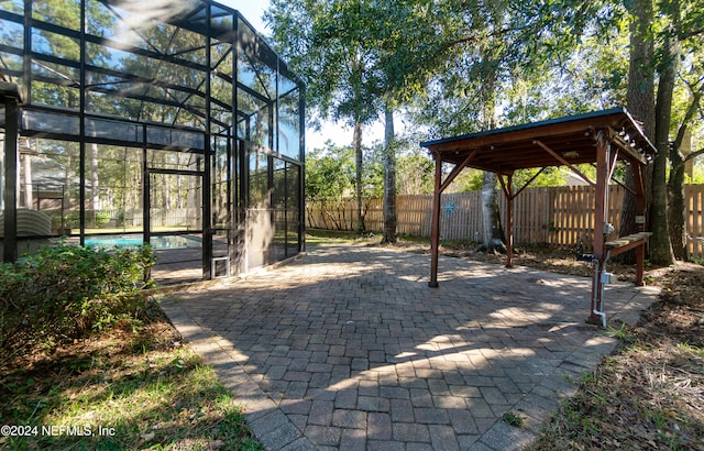 view of patio / terrace featuring a fenced in pool and glass enclosure