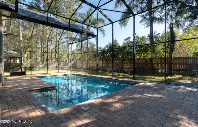 view of pool featuring glass enclosure and a patio area