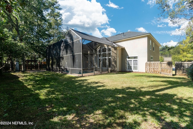 back of house featuring a lanai and a yard