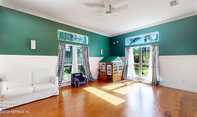 interior space with ceiling fan, wood-type flooring, crown molding, and a wealth of natural light