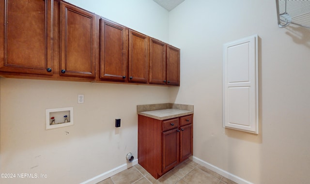 laundry area featuring hookup for a washing machine, light tile patterned floors, and cabinets