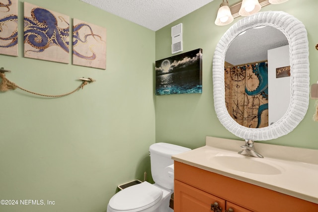 bathroom with a textured ceiling, toilet, and vanity