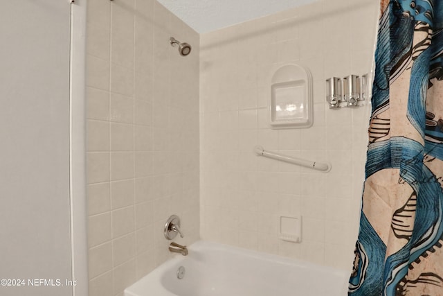 bathroom with tiled shower / bath and a textured ceiling