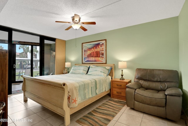 bedroom with ceiling fan, light tile patterned floors, access to exterior, and a textured ceiling