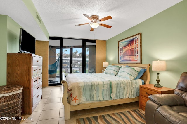 bedroom featuring ceiling fan, floor to ceiling windows, access to outside, a textured ceiling, and light tile patterned floors