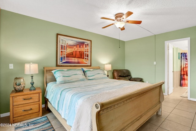 bedroom featuring ceiling fan, a textured ceiling, ensuite bathroom, and light tile patterned flooring