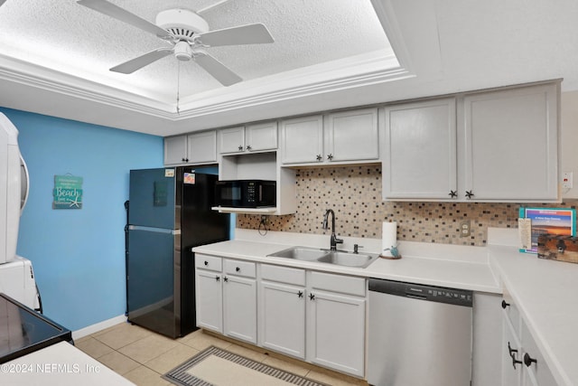 kitchen with appliances with stainless steel finishes, decorative backsplash, sink, a raised ceiling, and light tile patterned floors