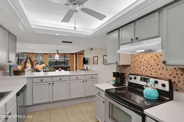 kitchen featuring a textured ceiling, appliances with stainless steel finishes, gray cabinets, a raised ceiling, and crown molding