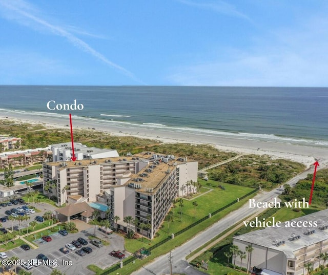 birds eye view of property with a water view and a view of the beach