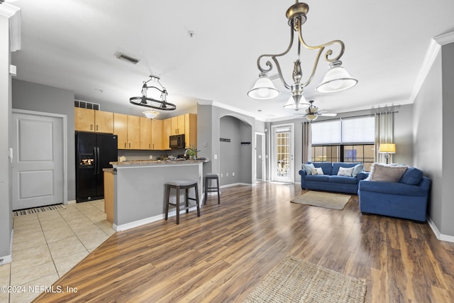 living room with wood-type flooring, ceiling fan, and crown molding