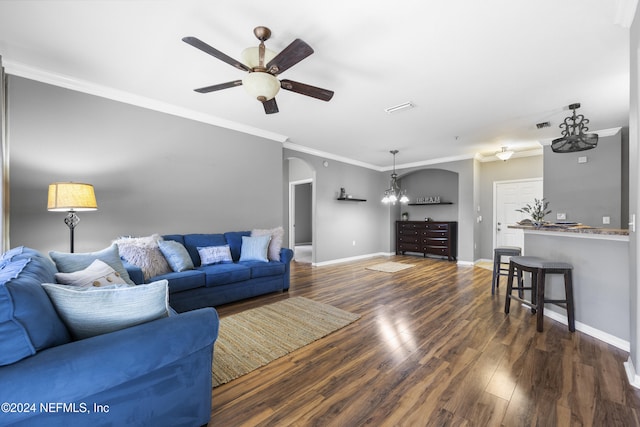 living room featuring ceiling fan with notable chandelier, ornamental molding, and dark wood-type flooring