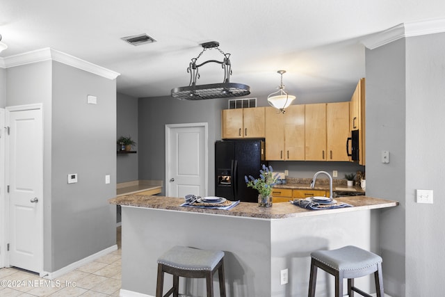 kitchen with a breakfast bar, black appliances, ornamental molding, light brown cabinetry, and kitchen peninsula