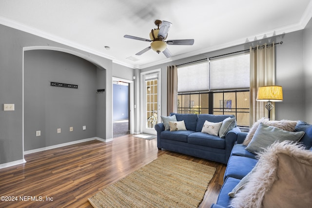 living room featuring ornamental molding, ceiling fan, and dark wood-type flooring