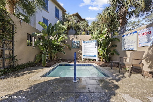 view of swimming pool featuring a community hot tub