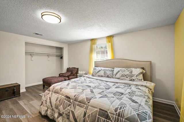 bedroom featuring a closet, wood-type flooring, and a textured ceiling